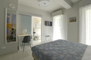 博尔迪盖拉Hotel Villa MIKI的一间卧室配有一张床、一张桌子和一把椅子