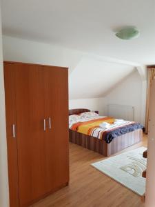波洛夫拉吉Casa de vacanta Macovei0744的一间卧室配有一张床和一个木制橱柜