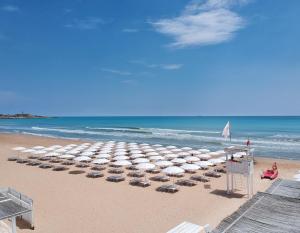 桑皮耶里VOI Marsa Siclà Essentia的海滩上设有椅子和遮阳伞,还有大海