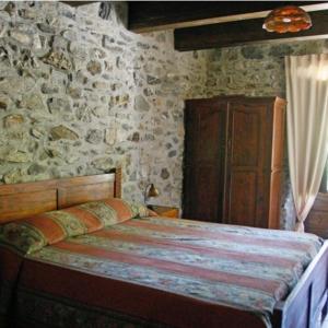 圣塞韦里诺卢卡诺Hotel Ristorante Mulino Iannarelli的一间卧室设有一张床和石墙