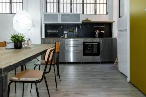 米兰ALTIDO Exclusive Apt for 4 in Navigli near parks的厨房配有长木桌子和椅子