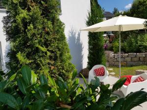 拉芬斯堡Business Apartment Ravensburg - sonnig, zentral & ruhig的庭院配有两把椅子和一把遮阳伞