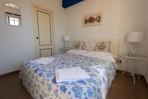 陶尔米纳Taormina Isola Bella Apartment - Taormina Holidays的一间卧室配有一张带蓝白色毯子的床