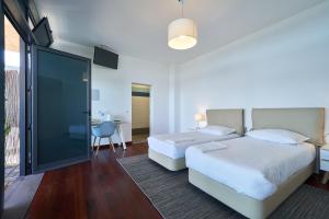 卡列塔Marina Rooms的一间卧室设有两张床和滑动玻璃门