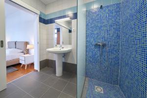 卡列塔Marina Rooms的浴室设有水槽和蓝色瓷砖淋浴。