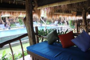 坎古棕榈树别墅酒店的游泳池前的长凳