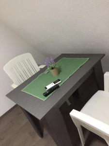 斯塔多伊兰Madzar Apartments的绿纸上带有遥控器的桌子