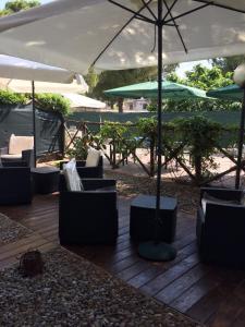 塔兰托Appartahotelpuglia Gruppo Albergo Lamanna的露台配有椅子和遮阳伞,位于甲板上