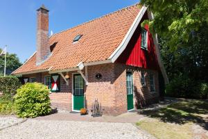 利费尔德De Brittenburg met privé hottub & sauna 4-persoons的红砖房子,带绿门