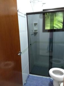 博西坎加RC Sol de Boiçucanga - Suite的一间带玻璃淋浴间和卫生间的浴室