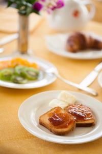 迪亚诺马里纳坎迪多酒店的一张桌子,上面放着两盘食物,有面包和黄油