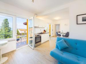 奥米沙利Appartments Adriatic的一间带蓝色沙发的客厅和一间厨房