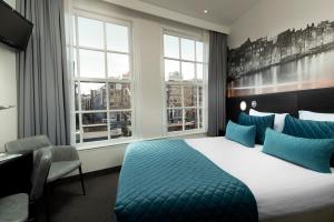 阿姆斯特丹阿姆斯特丹辛格尔酒店的酒店客房设有一张床、一张书桌和窗户。