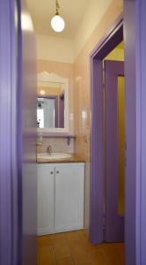 格拉多Casetta Liberty的一间带水槽和紫色门的浴室
