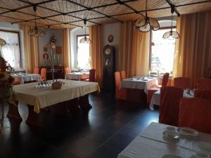 埃伦弗里德斯多夫Pension und Restaurant Die Burg的一间设有两张桌子和闹钟的用餐室