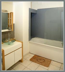 沃苏勒Appartements Baron Bouvier的带浴缸和盥洗盆的浴室