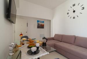 阿雷西费Apartamentos Bello Lanzarote的客厅配有沙发和墙上的时钟