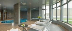 亚斯特雷巴斯科公主酒店的客厅设有游泳池和白色椅子