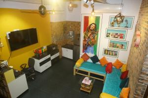 孟买Mumbai Staytion Dorm- Hostel的客厅配有蓝色的沙发和电视