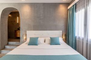 米克诺斯城Melangel的卧室配有带蓝色枕头的大型白色床