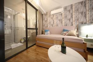扎达尔Central Apartments Integrated Hotel的一间卧室配有一张床和一张桌子及一瓶葡萄酒
