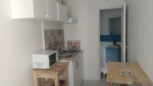 奥贝维利埃1 Bedroom Flat, 20m2, Metro line 7 direct to Louvre, near Olympic Sites -Parking & Wifi的一间带桌子和微波炉的小厨房