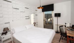 金塔尼利亚德奥内西莫La Casita de la Planta的白色卧室配有白色的床和书桌
