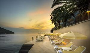 布尔纳阿米尼斯鲁姆酒店的海滩上一排躺椅和遮阳伞