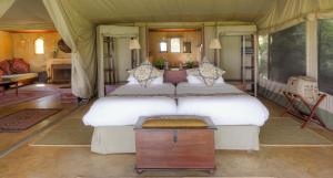 OlolaimutiekEntumoto Main Camp的一间帐篷内带两张床的卧室