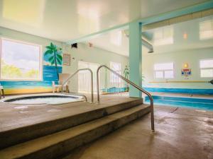 坎卢普斯乡村景汽车旅馆的一座大楼内带热水浴池的游泳池