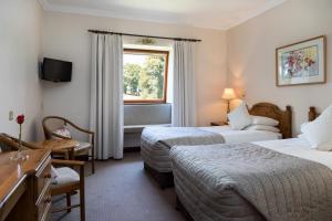 基拉尼凯思林乡间别墅酒店的酒店客房设有两张床和窗户。