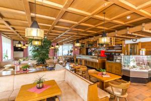 拉瓦莱Hotel Alpenrose Dolomites的餐厅设有木制天花板和桌椅
