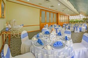 危地马拉桑坦德广场酒店的宴会厅配有带蓝白色椅子的桌子