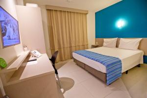 阿拉卡茹阿拉卡茹格因酒店的配有一张床和一张书桌的酒店客房
