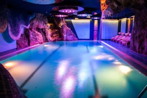 费拉迪普利米罗Hotel Mirabello - Slow Hotel Benessere的紫色灯火的洞穴游泳池