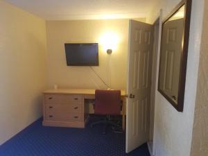 塔拉哈西拉卡萨酒店及套房的客房设有书桌、电视和椅子