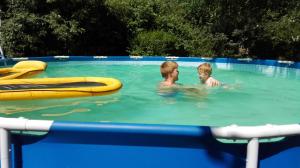 Herne常春藤住宿加早餐旅馆的两个男孩在带木筏的游泳池游泳