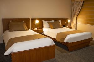 基多卡洛琳娜蒙特卡洛酒店的酒店客房设有两张床和两盏灯。