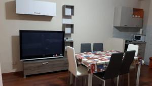 CasavatoreCasa Giovanni的一间带桌椅和电视的用餐室