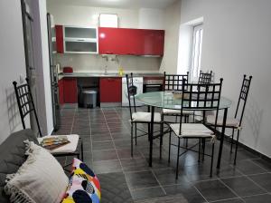 法鲁Sleep & Go Faro Airport Guest House的厨房配有红色橱柜和桌椅