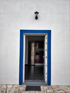 法鲁Sleep & Go Faro Airport Guest House的一道蓝色的门通向一个白色墙壁的房间
