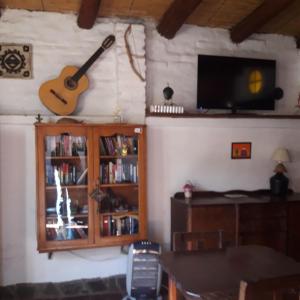 卡法亚特Hostal Rustyk的客厅配有挂在墙上的吉他