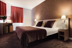 昂蒂布Hôtel de l'Étoile的酒店客房设有一张大床和红色窗帘