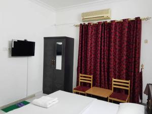 沙迦索菲亞酒店的配有床和两把椅子及一台电视的房间