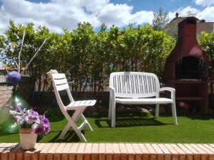 锡耶纳Casa Arcobaleno的两把白色椅子坐在院子里的草地上