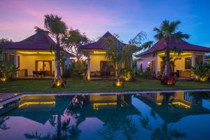 金巴兰Bali Mynah Villas Resort的夜间带游泳池的别墅