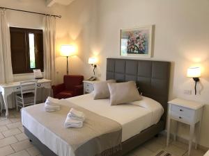 卡斯特拉纳格罗泰Relais Masseria Serritella的一间卧室配有一张床、一张桌子和一把椅子
