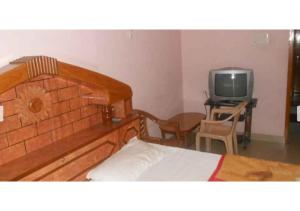 布什格尔Peaceful Palace in Pushkar的一间卧室配有一张床和一台小电视