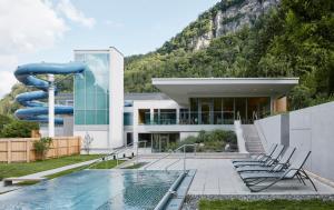 布鲁登茨Val Blu Sport | Hotel | SPA的一座带游泳池和水滑梯的房子