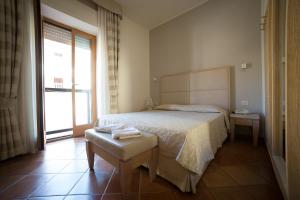 卡斯蒂里昂纳·德拉佩米拉马雷酒店的一间卧室设有一张床和一个大窗户